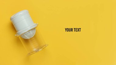 Sarı arka planda plastik elle meyve sıkacağı. Üst Manzara. Boşluğu kopyala