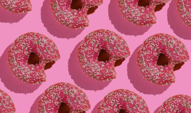 Pembe arka planda ısırılmış donutlardan oluşan pop sanat kolajı. Yemek arkaplanı. Üst görünüm