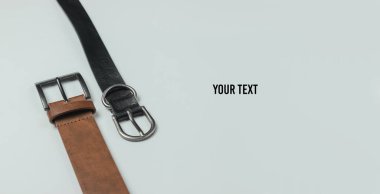 Beyaz arka planda iki deri kemer, yakın plan. Boşluğu kopyala