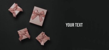 Siyah arka planda fiyonklu hediye kutuları. Noel kompozisyonu, Kara Cuma