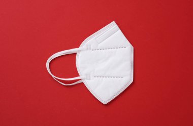 Kırmızı arka planda K95 tıbbi maske. Üst görünüm