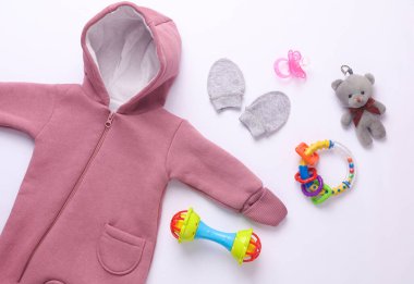 Beyaz arka planda yeni doğan kıyafetleri, aksesuarlar ve oyuncaklar. Düz yatıyordu. Üst görünüm