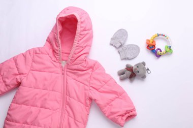 Beyaz arka planda yeni doğan kıyafetleri, aksesuarlar ve oyuncaklar. Düz yatıyordu. Üst görünüm