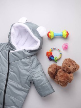 Beyaz arka planda yeni doğan kıyafetleri, aksesuarlar ve oyuncaklar. Düz yatıyordu. Üst görünüm