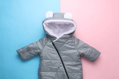 Pembe mavi arka planda yeni doğmuş bir bebek için kapüşonlu ılık kış gürültüsü