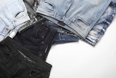 Beyaz arka planda birçok farklı modaya uygun kot pantolon çeşitleri