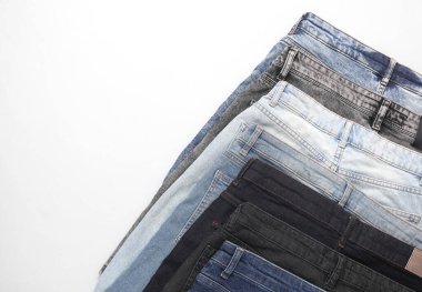 Beyaz arka planda farklı kot pantolonlar.