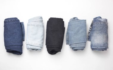 Beyaz arka planda sarılmış kot pantolon. Üst görünüm