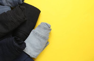 Sarı arka planda sarılmış kot pantolon. Üst görünüm