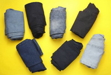 Sarı arka planda sarılmış kot pantolon. Üst görünüm