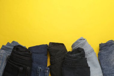 Sarı arka planda sarılmış kot pantolon. Üst görünüm