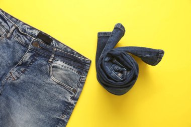 Sarı arka planda sarılmış kot pantolon. Üst görünüm