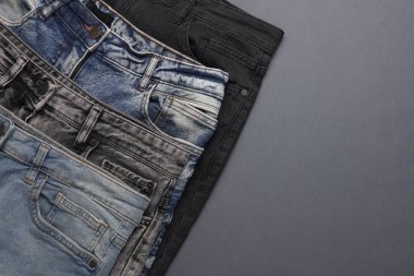 Gri arka planda bir sürü kot pantolon. Üst Manzara. & Boşluk