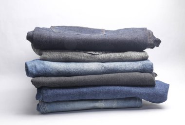Beyaz arka planda bir sürü kot pantolon