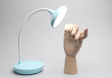 Masa esnek kablosuz lamba, gri arka planda tahta el.