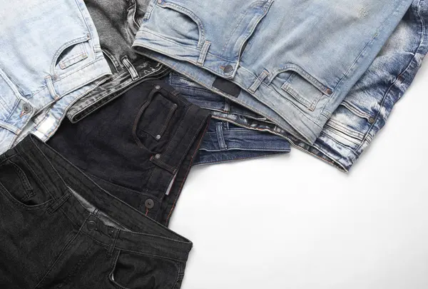 Beyaz arka planda birçok farklı modaya uygun kot pantolon çeşitleri