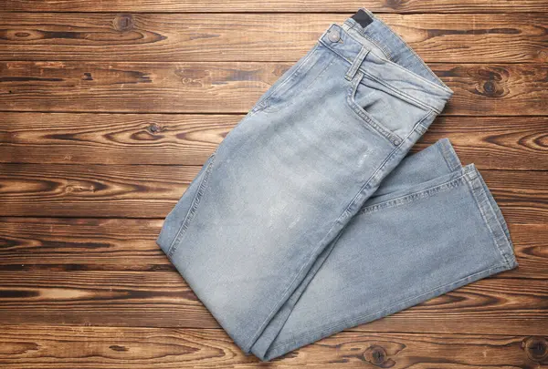 Ahşap arka planda mavi kot pantolon