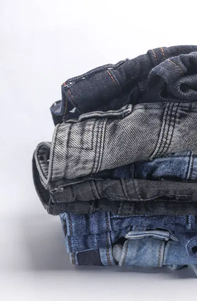 Beyaz arka planda bir sürü kot pantolon