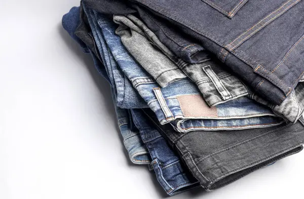 Beyaz arka planda bir sürü kot pantolon