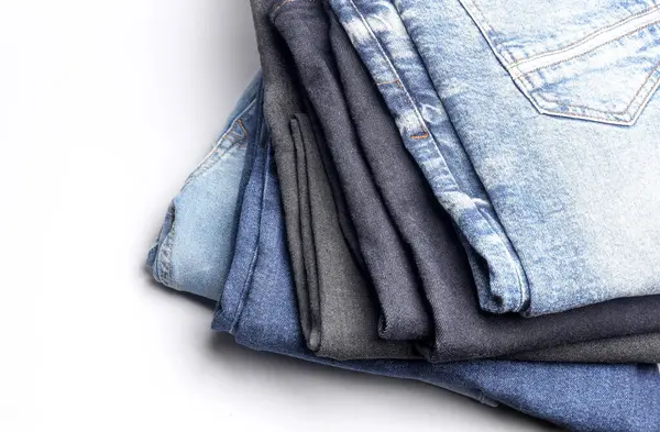 Beyaz arka planda bir sürü kot pantolon