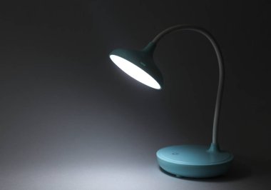LED masa lambası gri bir arka planda parlar