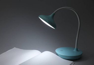 Masa lambası, arka plandaki boş dergi modelini aydınlatıyor. Karartma, iş kavramı