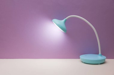 Mor arkaplanda masaüstü kablosuz esnek LED lambası