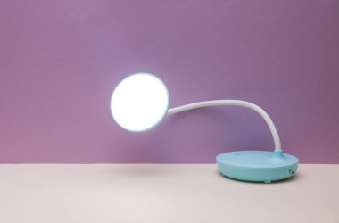 Mor arkaplanda masaüstü kablosuz esnek LED lambası