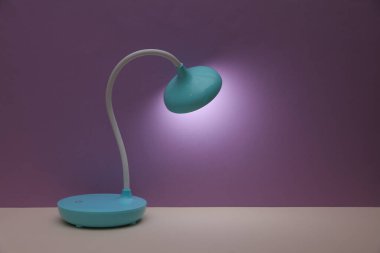 Mor arkaplanda masaüstü kablosuz esnek LED lambası