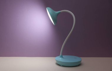 Mor arkaplanda masaüstü kablosuz esnek LED lambası