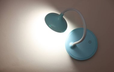 LED masa lambası bej arka planda parlar. Üst görünüm