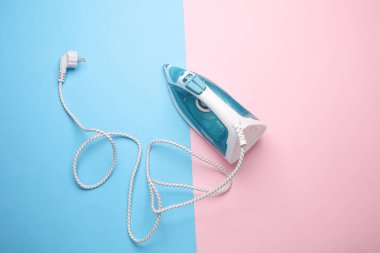 Mavi-pembe arka planda ütü yapmak için ütü. Üst görünüm