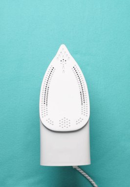 Mavi kumaş zemin üzerinde ütü yapılıyor