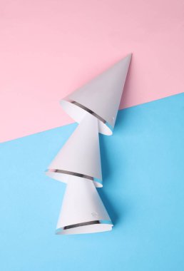 Mavi pembe arka planda doğum günü konileri şapkaları