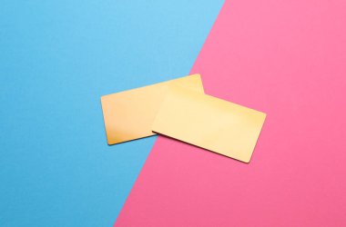 Mavi-pembe arka planda altın kartvizitler. Üst görünüm