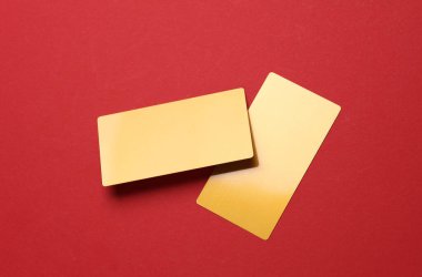 Kırmızı arkaplanda altın kartvizitler.