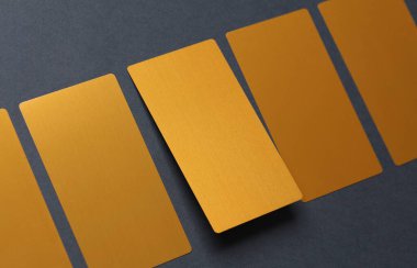 Koyu gri arkaplanda altın kartvizitler.