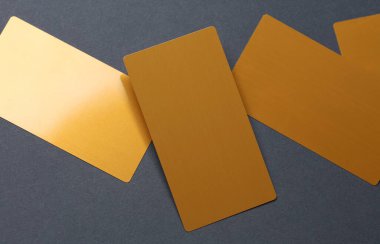 Koyu gri arkaplanda altın kartvizitler.