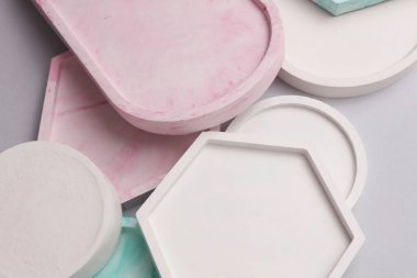 Alçı geometrik şekiller, gri arkaplanda tepsiler