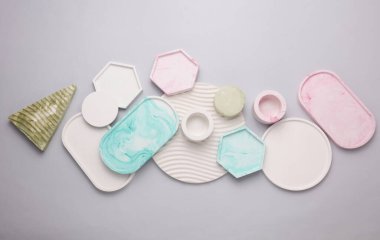 Alçı geometrik şekiller, gri arka planda tepsiler. Üst görünüm