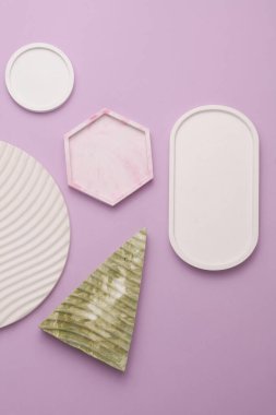 Alçı geometrik şekiller, mor yeşil arka planda tepsiler. Üst görünüm