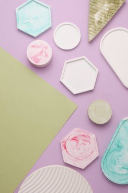 Alçı geometrik şekiller, mor yeşil arka planda tepsiler. Üst görünüm