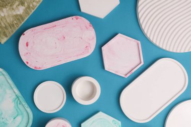 Alçı geometrik şekiller, mavi arka planda dekoratif tepsiler. Üst görünüm