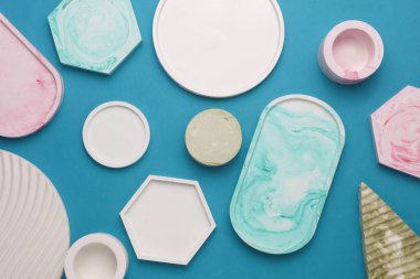 Alçı geometrik şekiller, mavi arka planda dekoratif tepsiler. Üst görünüm