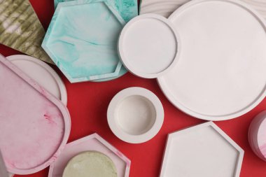 Alçı geometrik şekiller, kırmızı arka planda tepsiler. Üst görünüm