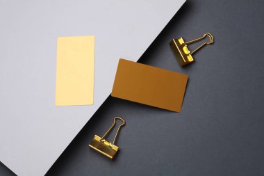 Gri arkaplandaki altın kartvizitler ve klasörler