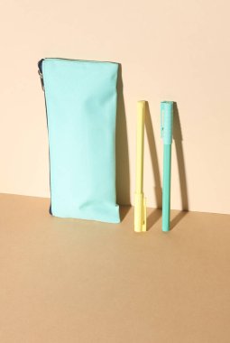 Bej arka planda renkli kalemleri olan kalem kutusu. Yaratıcı yerleşim