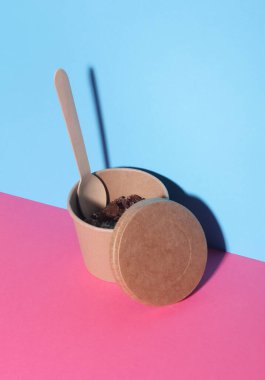 Karton ürün kabında üzümlü yulaf ezmesi mavi pembe arka planda yiyecek kabı