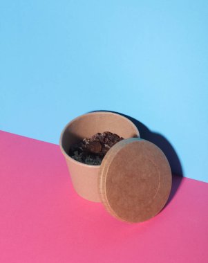 Karton ürün kabında üzümlü yulaf ezmesi mavi pembe arka planda yiyecek kabı