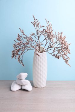 İskandinav tarzında minimalist vazo. Masada kurumuş çiçekler, mavi arka plan.